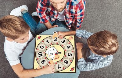 Plateau de jeu Mathsumo autour duquel se trouve deux enfants et leur papa.
